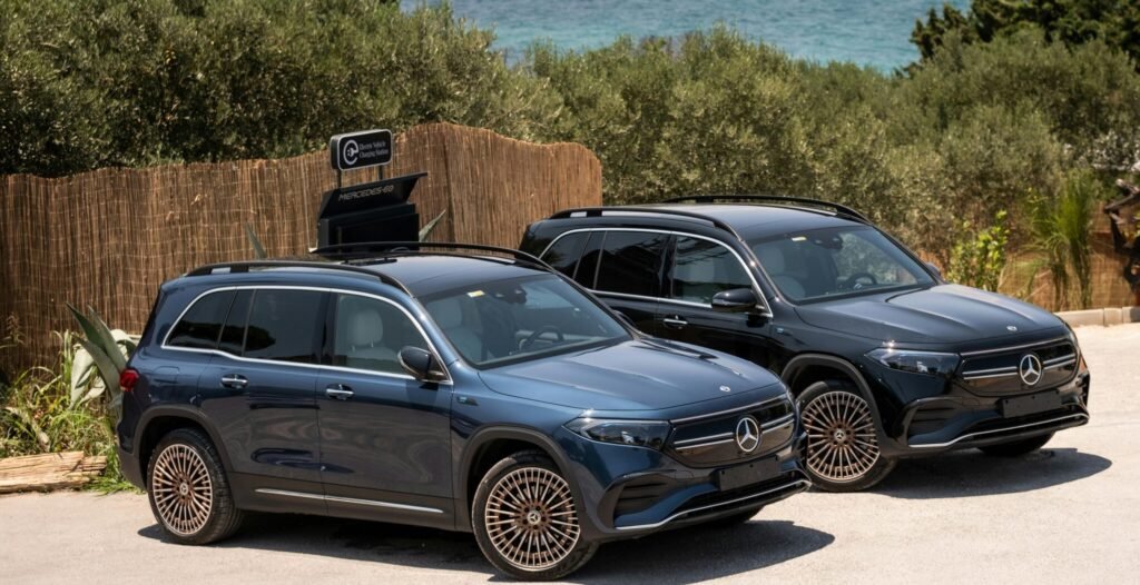 Two Mercedes EQB SUVs parked by the sunlit coast in İzmir, Türkiye.