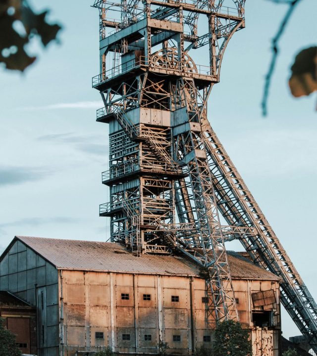 Rusty industrial mining tower in Heusden-Zolder, Belgium during daylight.
